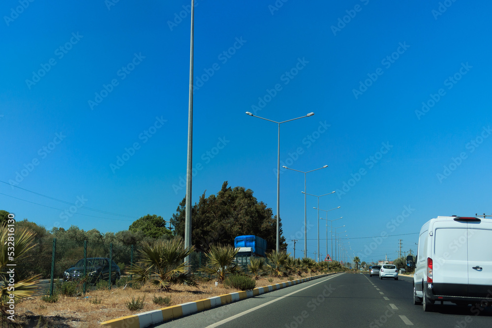 Fototapeta premium Highway wide road, transport and blue sky with clouds on a summer day
