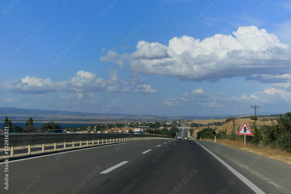 Naklejka premium Highway wide road, transport and blue sky with clouds on a summer day