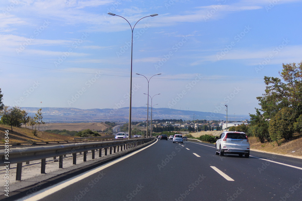 Fototapeta premium Highway wide road, transport and blue sky with clouds on a summer day
