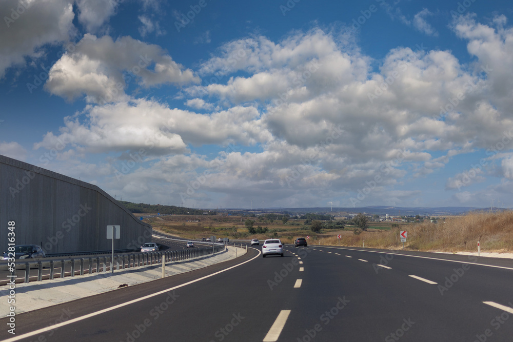 Fototapeta premium Highway wide road, transport and blue sky with clouds on a summer day