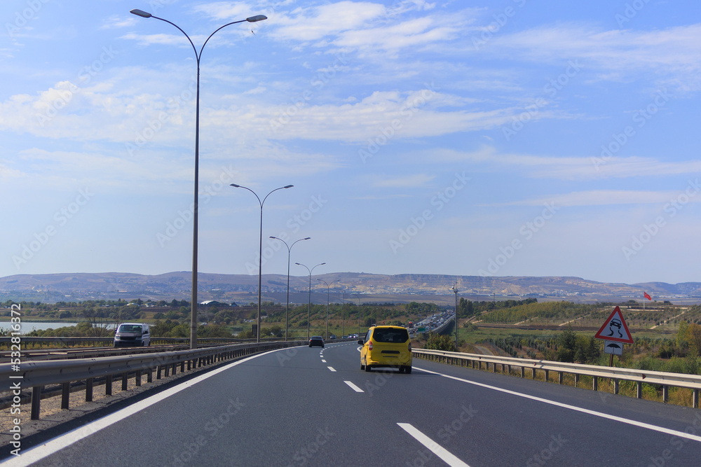 Fototapeta premium Highway wide road, transport and blue sky with clouds on a summer day