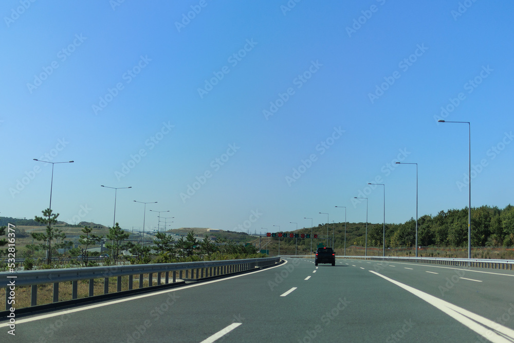 Fototapeta premium Highway wide road, transport and blue sky with clouds on a summer day