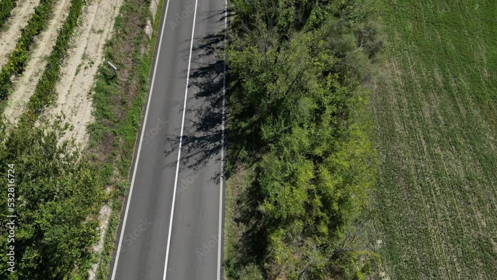 Verdi colline con cielo nuvoloso, con una piccola strada che li costeggia Verdi colline con cielo nuvoloso, con una piccola strada che li costeggia