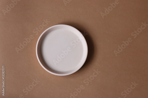 Blank mock up clay plate on brown background