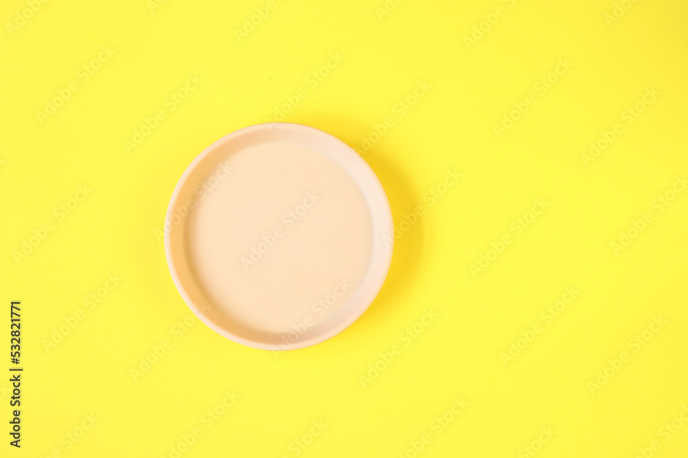 Clay plate on yellow background