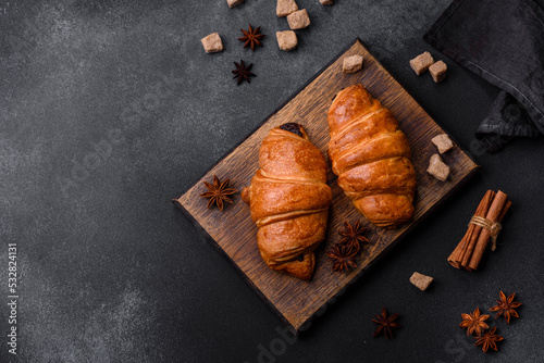 Fresh crisp chocolate croissants on wooden cutting board
