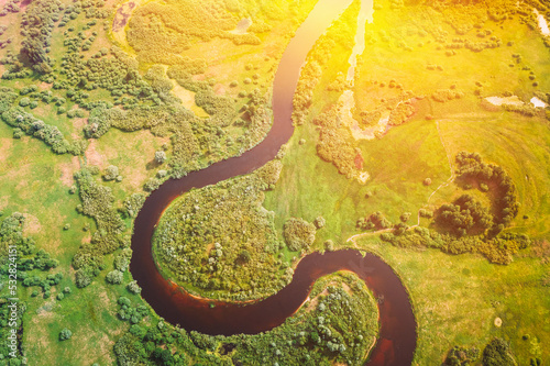 Aerial View Of Summer Curved River Landscape. Top View Of Beautiful European Nature From High Attitude. Drone Flight View. Bird s Eye View Of Green Forest Woods In Sunny Day. River Forms Sign Omega.