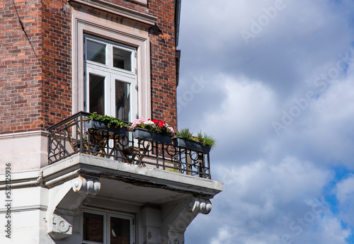 Photography Cute old balcony with flowers and a window in an old blick house