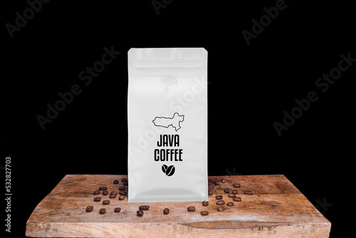 Java coffee beans and white package on wooden board with black isolated background