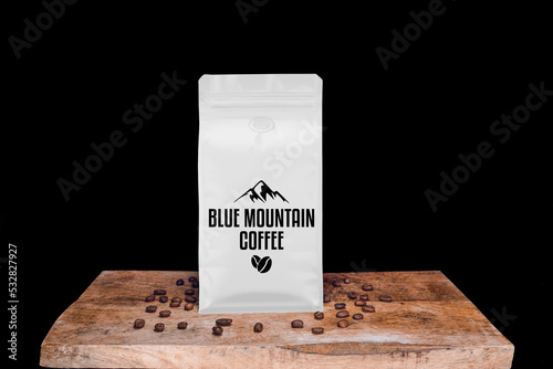 Blue Mountain coffee beans and white package on wooden board with black isolated background