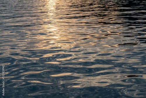 Sonnenuntergang spiegelt sich im welligen Meer © Patrick