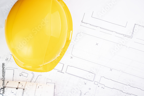 construction projects background, builder's hard hat lies on architectural blueprints