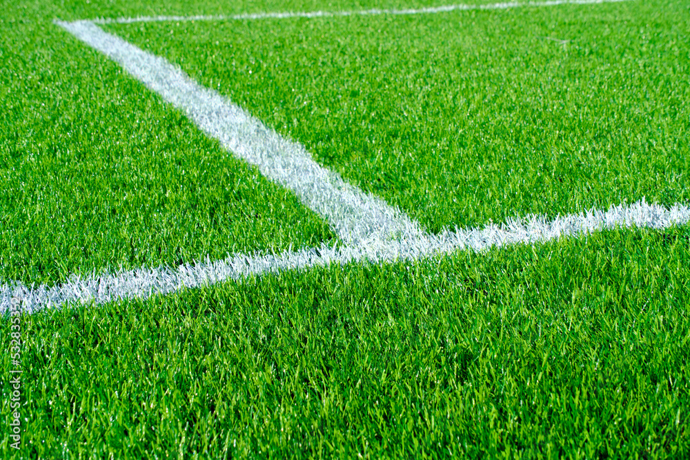 Fresh green lawn with markings on football field.