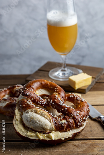 German Pretzel called Brezel,pastry from Southern with butter and glass of beer Germany,very popular in Oktoberfest.