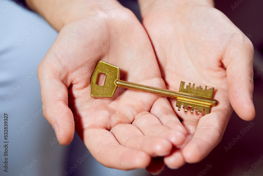 Fototapeta premium Close up of human hand holding golden key