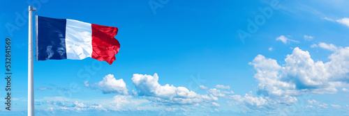 France flag waving on a blue sky in beautiful clouds - Horizontal banner