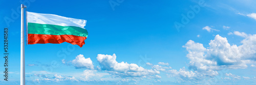 Bulgaria flag waving on a blue sky in beautiful clouds - Horizontal banner