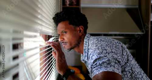 Schilderij op canvas African man looking through window blinds