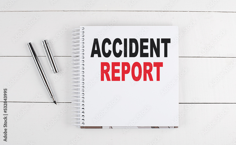 ACCIDENT REPORT text written on notebook on the wooden background ACCIDENT REPORT text written on notebook on the wooden background