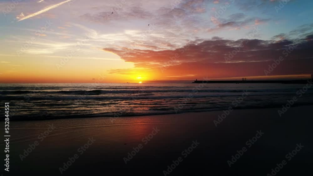 Flying Over Beach Sea Waves at Stunning Sunset. Colorful Clouds in the Background. Beautiful Nature Landscape. Travel Destination. Flying Over Beach Sea Waves at Stunning Sunset. Colorful Clouds in the Background. Beautiful Nature Landscape. Travel Destination.