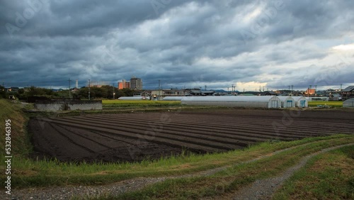 Timelapse: Fast moving clouds over unplanted field as farmer makes rounds at dawn