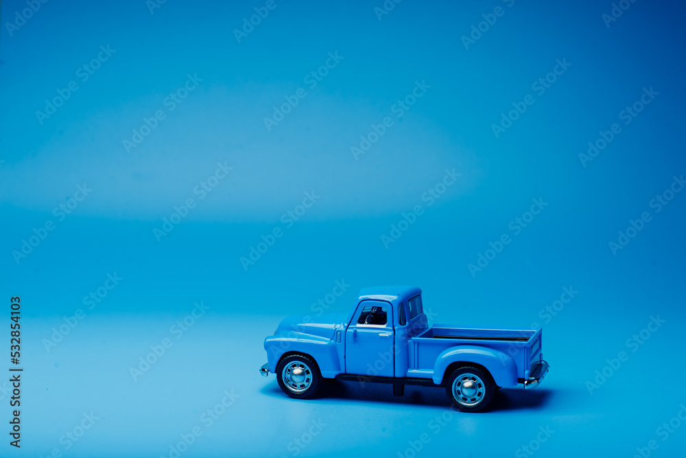 Toy blue pickup truck on a blue background