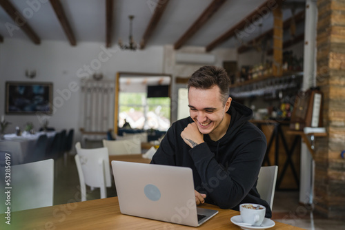 one man work on the computer laptop while sit at cafe or restaurant