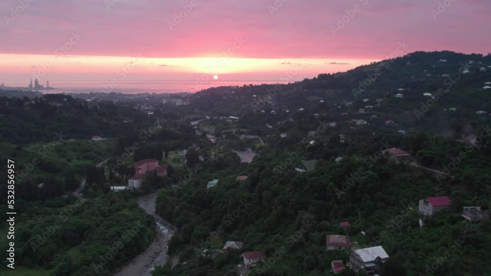 View on pink sunset in mountain village. High quality aerial 4k footage View on pink sunset in mountain village. High quality aerial 4k footage