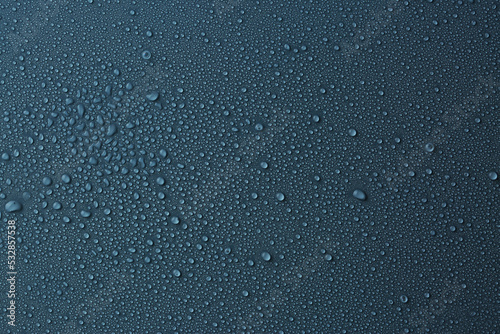 Many water drops on dark dusty blue background