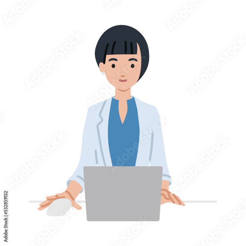 デスクで座ってPCを使っているジャケットの女性