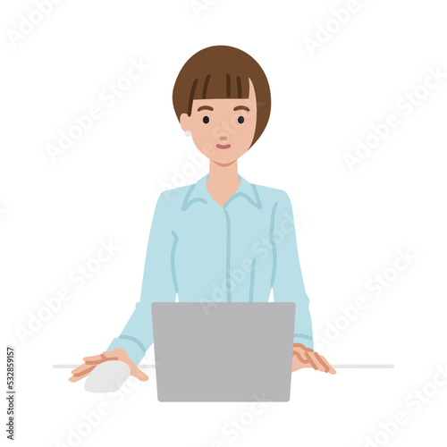 デスクで座ってPCを使っているブラウスの女性