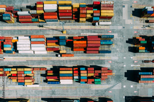 Aerial drone top down view of containers spread across a busy port, logistic and international trade concept