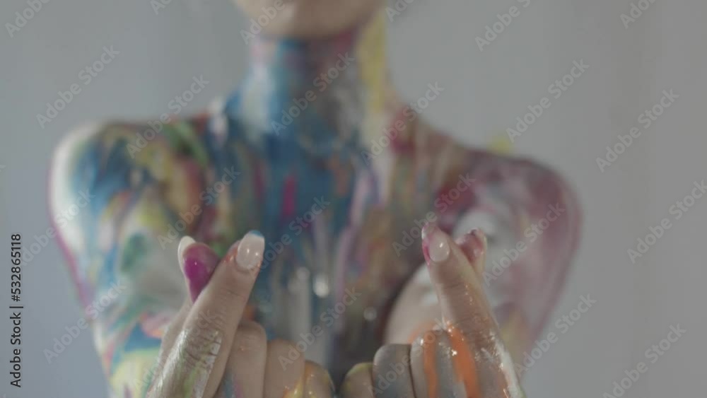 Close-up of the hands and fingers of a female model covered in wet body ...