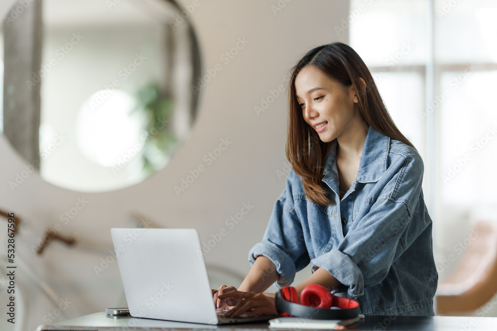 Young happy pretty asian woman using laptop at cafe. Young happy pretty asian woman using laptop at cafe.