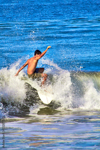 Photography man surfing a wave , vertical picture in zicatela, puerto escondido oaxaca