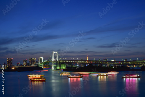 Rainbow bridge at night with yakatabune japanese party boats in tokyo photo