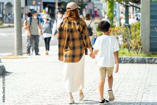 街中を手をつないで歩いている日本人の母と子供