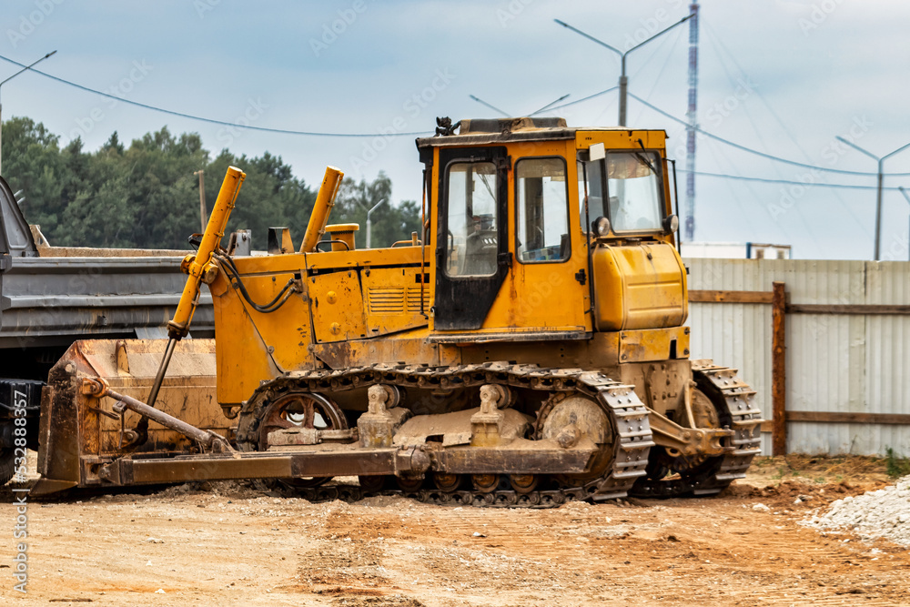 Powerful crawler bulldozer close-up at the construction site. Construction equipment for moving large volumes of soil. Modern construction machine. Road building machine.