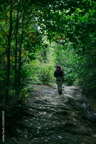A woman walking alone through the forest.
