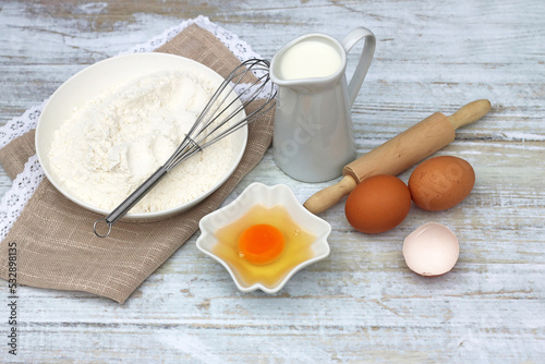 Küchentisch mit  Eiern, Mehl und Milch. photo