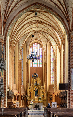 Main nave with altar and presbytery of historic Holy Mary gothic Kosciol Mariacki church in old town quarter of Trzebiatow in Poland