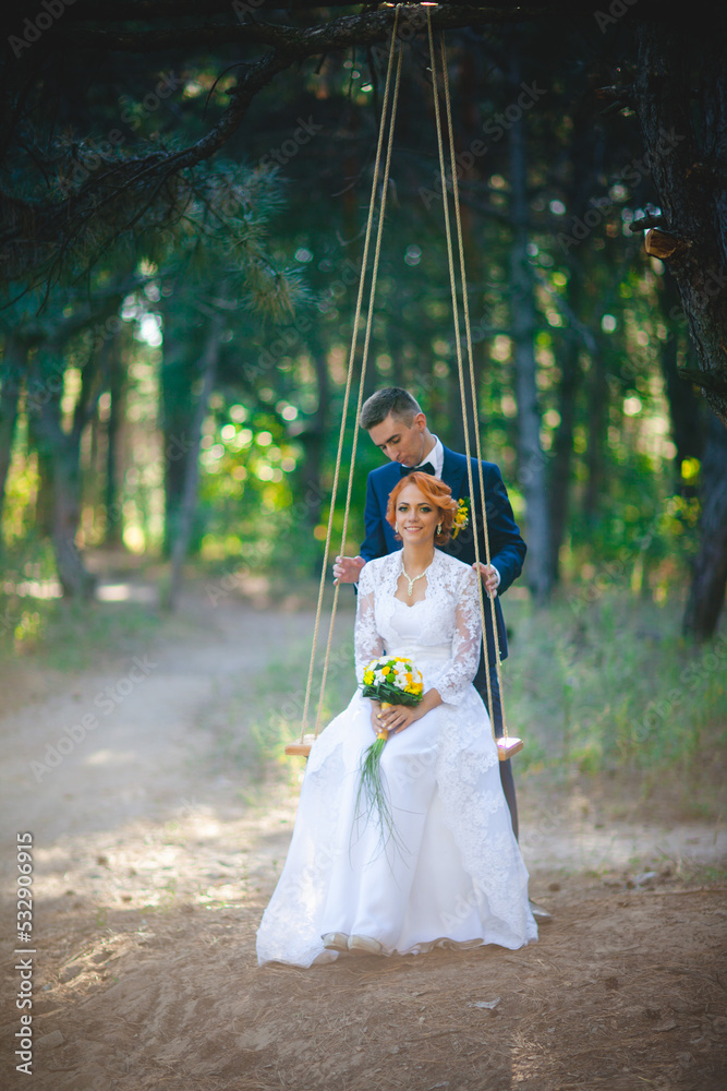 Young beautiful couple in a blue suit and white wedding dress with a bouquet Young beautiful couple in a blue suit and white wedding dress with a bouquet
