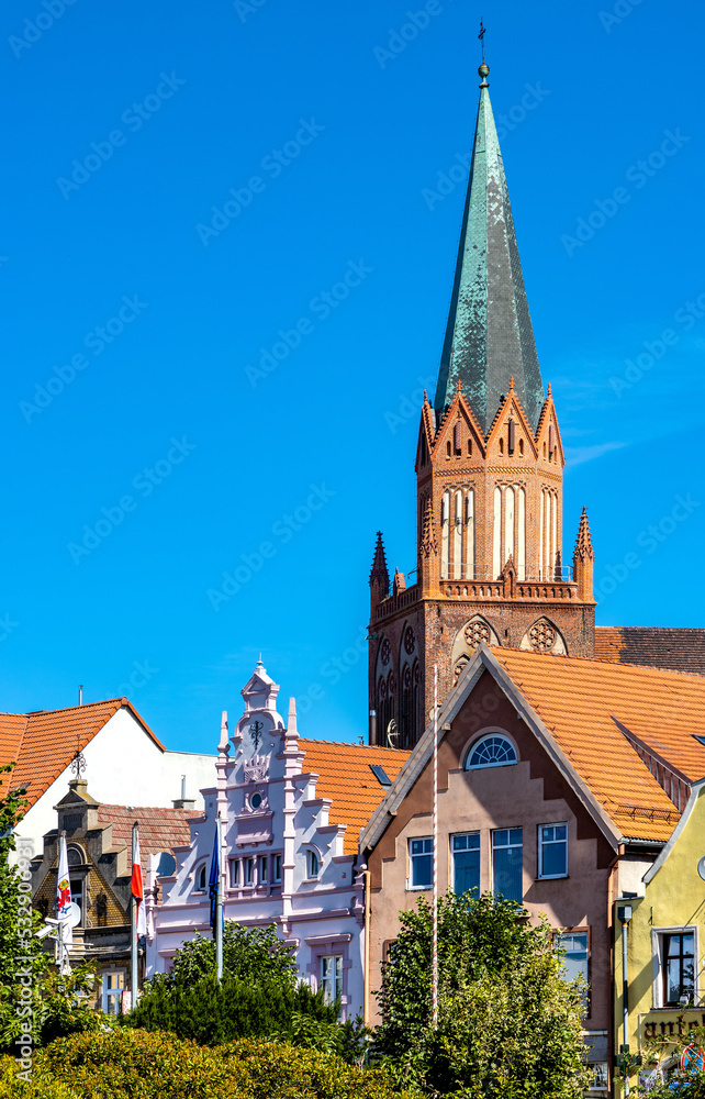 Obraz premium Panorama of Rynek main market square with Holy Mary gothic church in old town quarter of Trzebiatow in Poland