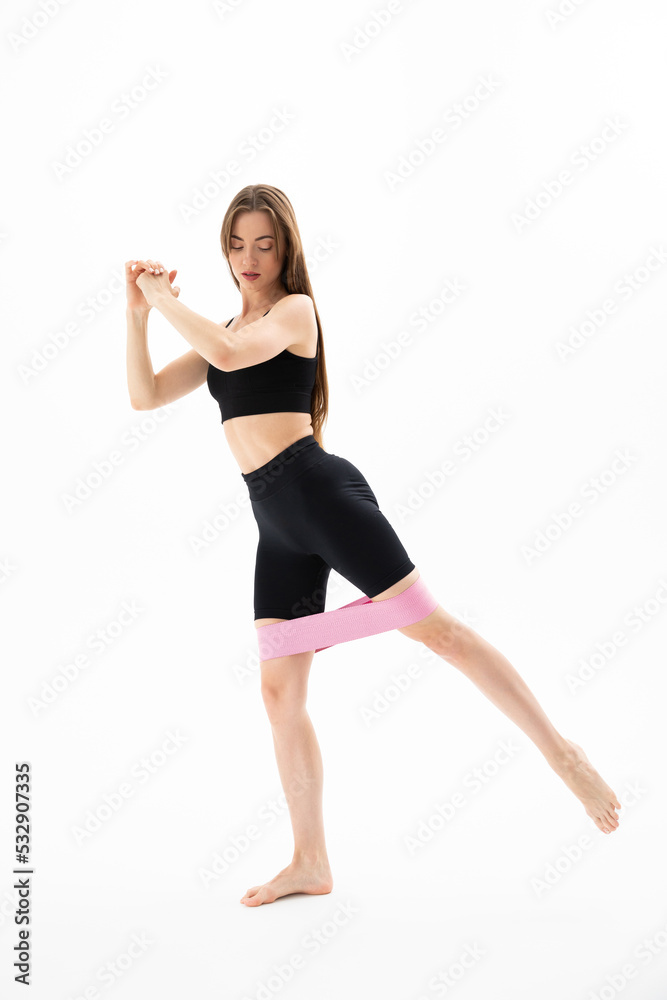 Sporty young woman doing stretching work out with elastic bands
