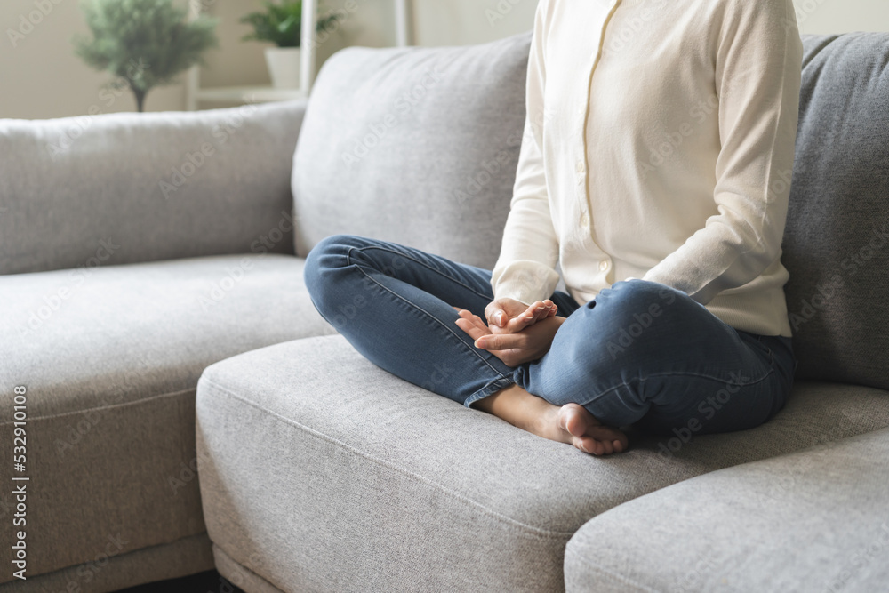 Beautiful asian young woman, girl hands in calm pose sitting practice meditating in lotus position on sofa at home, meditation, exercise for wellbeing, healthy care. Relaxation, happy leisure people. Beautiful asian young woman, girl hands in calm pose sitting practice meditating in lotus position on sofa at home, meditation, exercise for wellbeing, healthy care. Relaxation, happy leisure people.