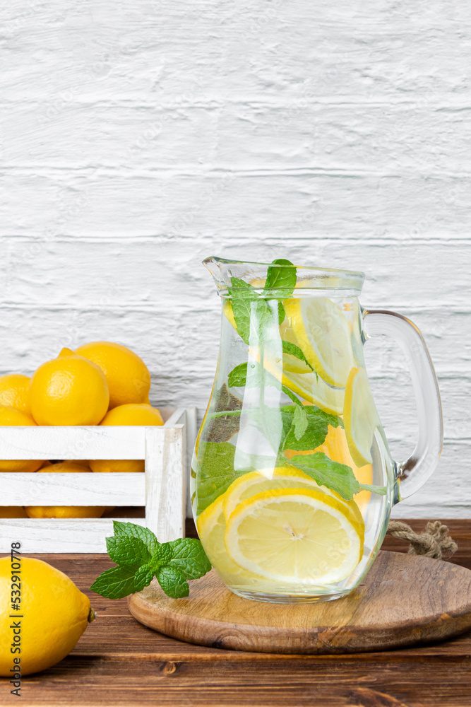 Fototapeta premium Lemonade with mint in jug and lemons in crate
