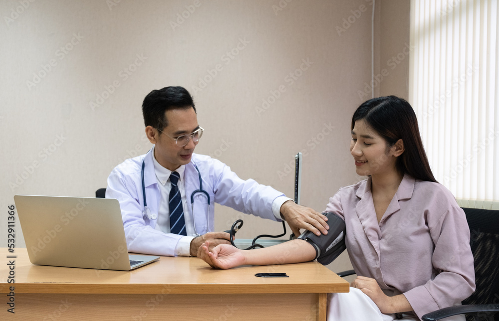 Doctor measures the blood pressure of a female patient Doctor measures the blood pressure of a female patient