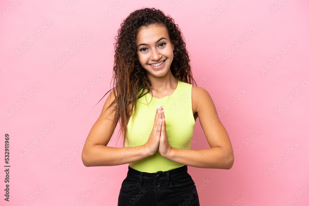 Young hispanic woman isolated on pink background keeps palm together. Person asks for something