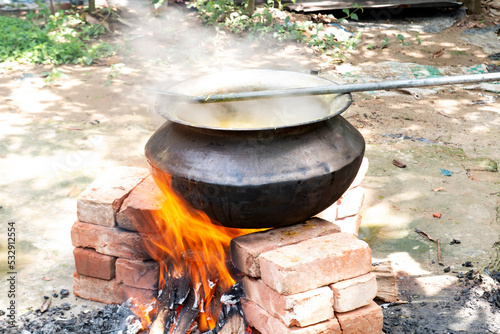 Biryani cooking in a village party on a temporary brick made oven. Outdoor cooking for lots of people in large aluminum pan with wooden fire.