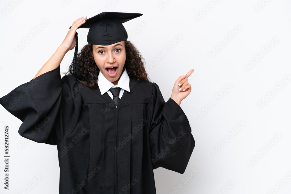 Young university graduate Arab woman isolated on white background surprised and pointing finger to the side